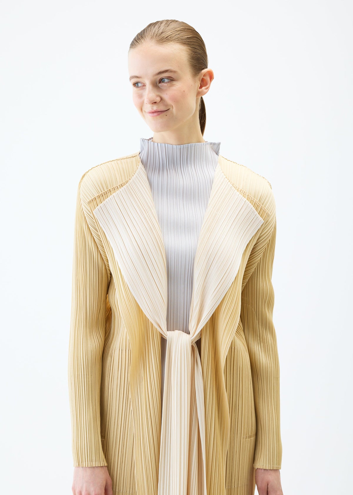 A model wears the PLEATS PLEASE ISSEY MIYAKE MERRY BICOLOR coat.