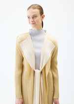 A model wears the PLEATS PLEASE ISSEY MIYAKE MERRY BICOLOR coat.