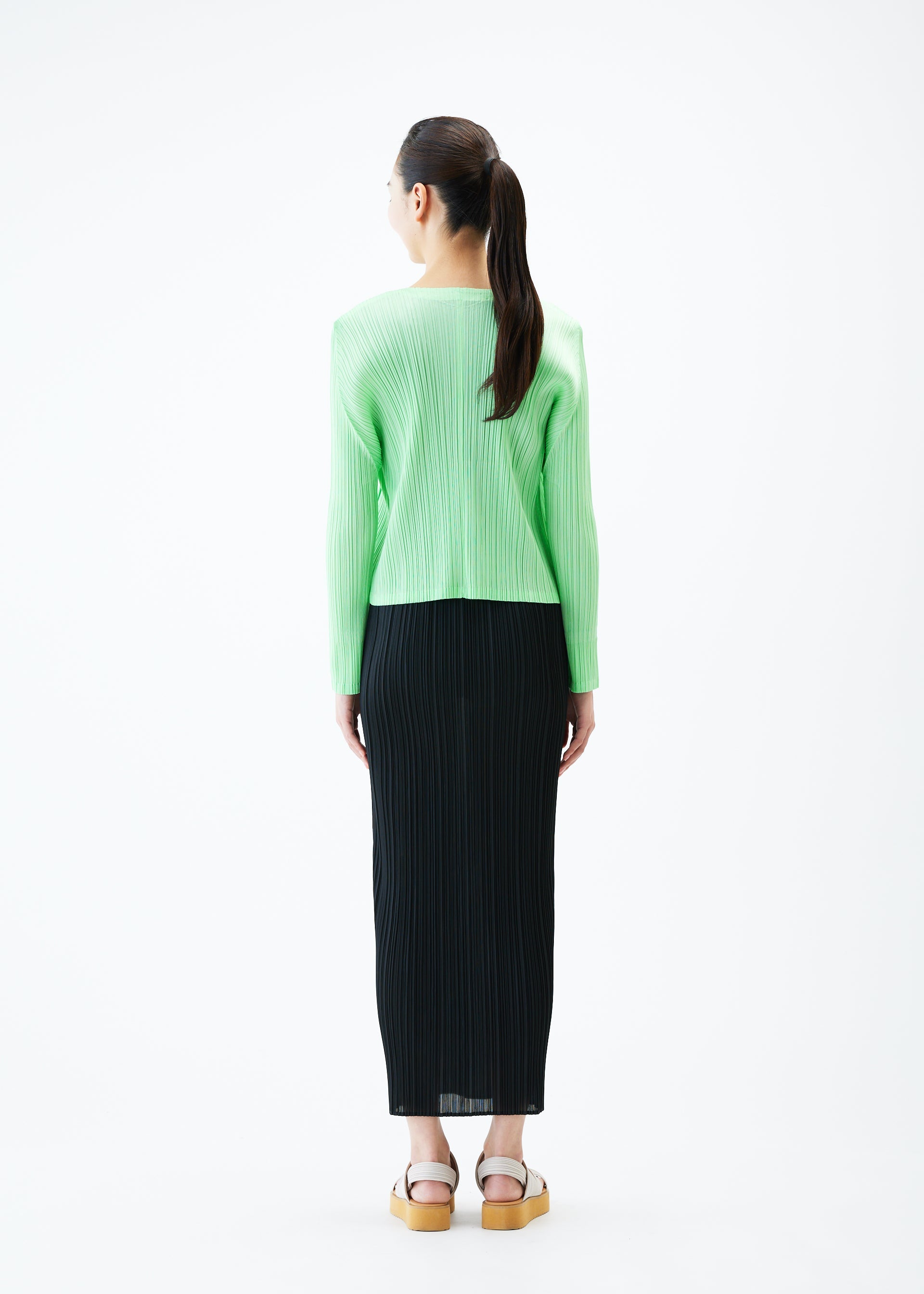 A model wears the PLEATS PLEASE ISSEY MIYAKE MONTHLY COLORS MAY jacket.