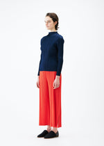 A model wears the PLEATS PLEASE ISSEY MIYAKE MONTHLY COLORS FEBRUARY trousers.