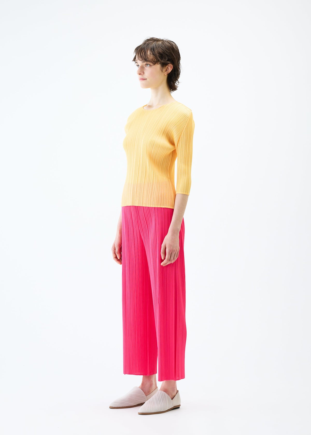 A model wears the PLEATS PLEASE ISSEY MIYAKE MONTHLY COLORS MARCH trousers.