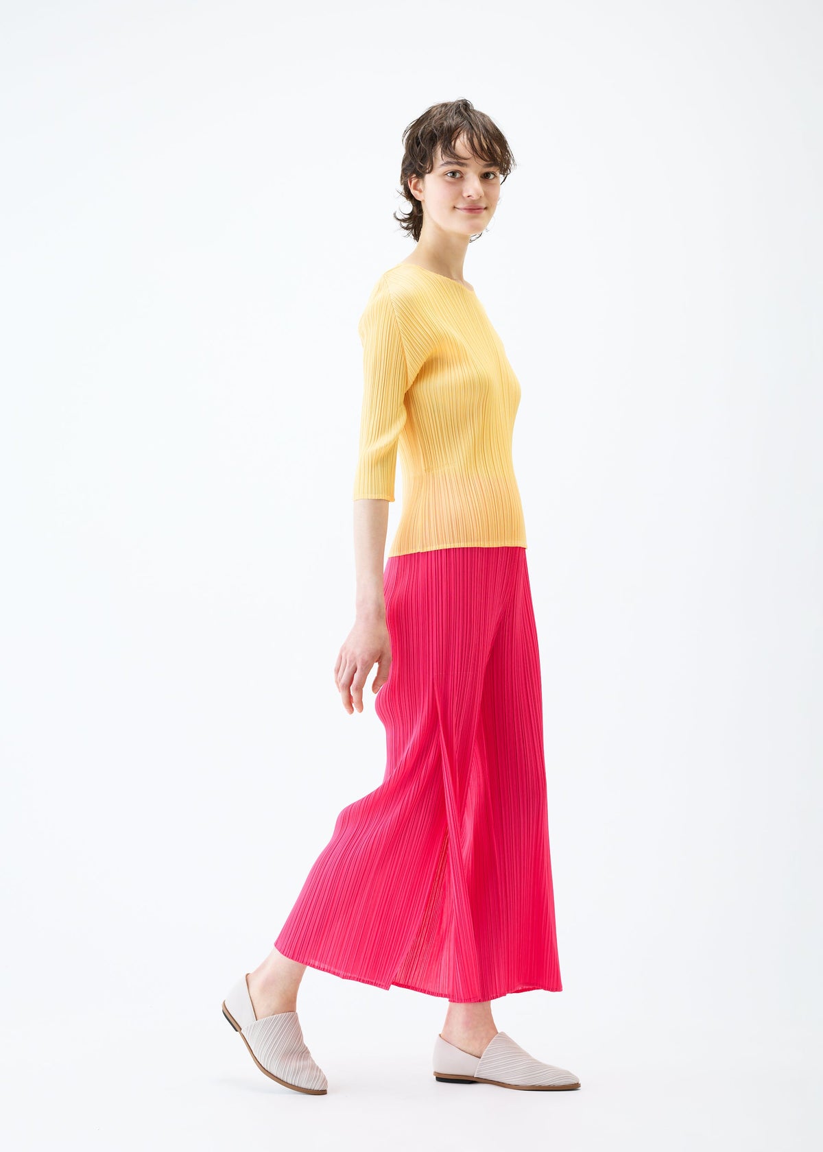 A model wears the PLEATS PLEASE ISSEY MIYAKE MONTHLY COLORS MARCH trousers.