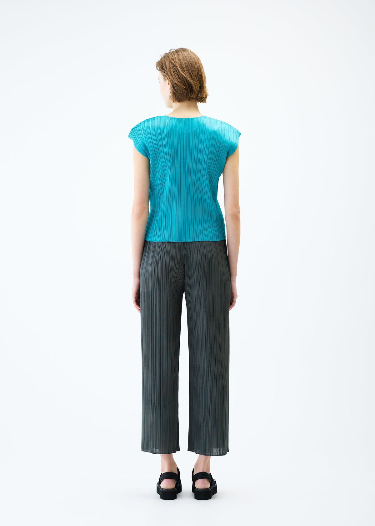 A model wears the PLEATS PLEASE ISSEY MIYAKE MONTHLY COLORS : JUNE trousers.