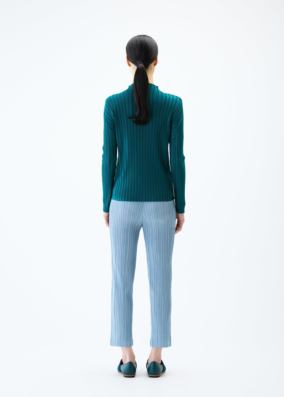 A model wears the PLEATS PLEASE ISSEY MIYAKE THICKER BOTTOMS 1 trousers.