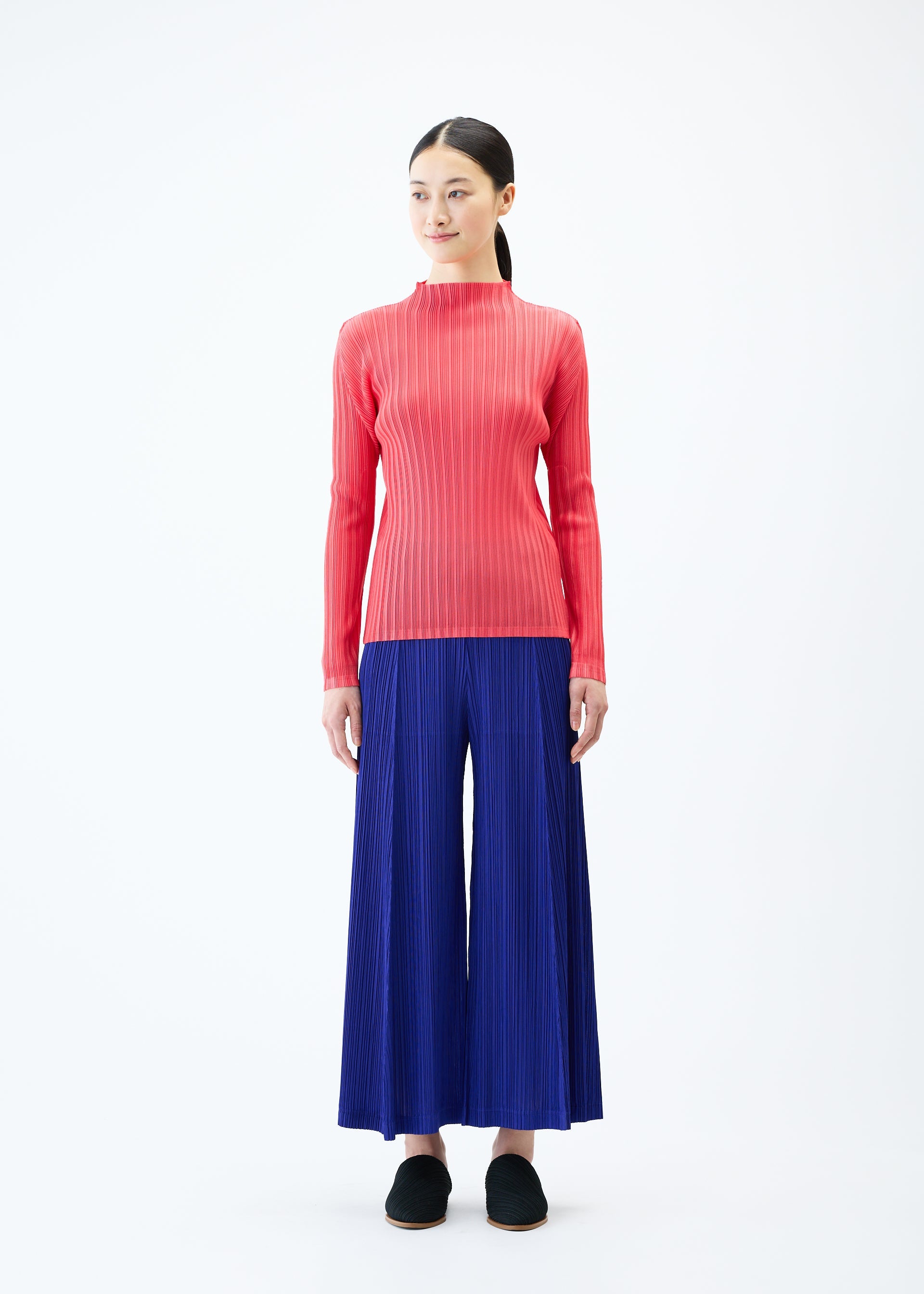 A model wears the PLEATS PLEASE ISSEY MIYAKE THICKER BOTTOMS 1 trousers.