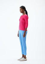 A model wears the PLEATS PLEASE ISSEY MIYAKE THICKER BOTTOMS 2 trousers.