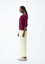 A model wears the PLEATS PLEASE ISSEY MIYAKE THICKER BOTTOMS 2 trousers.