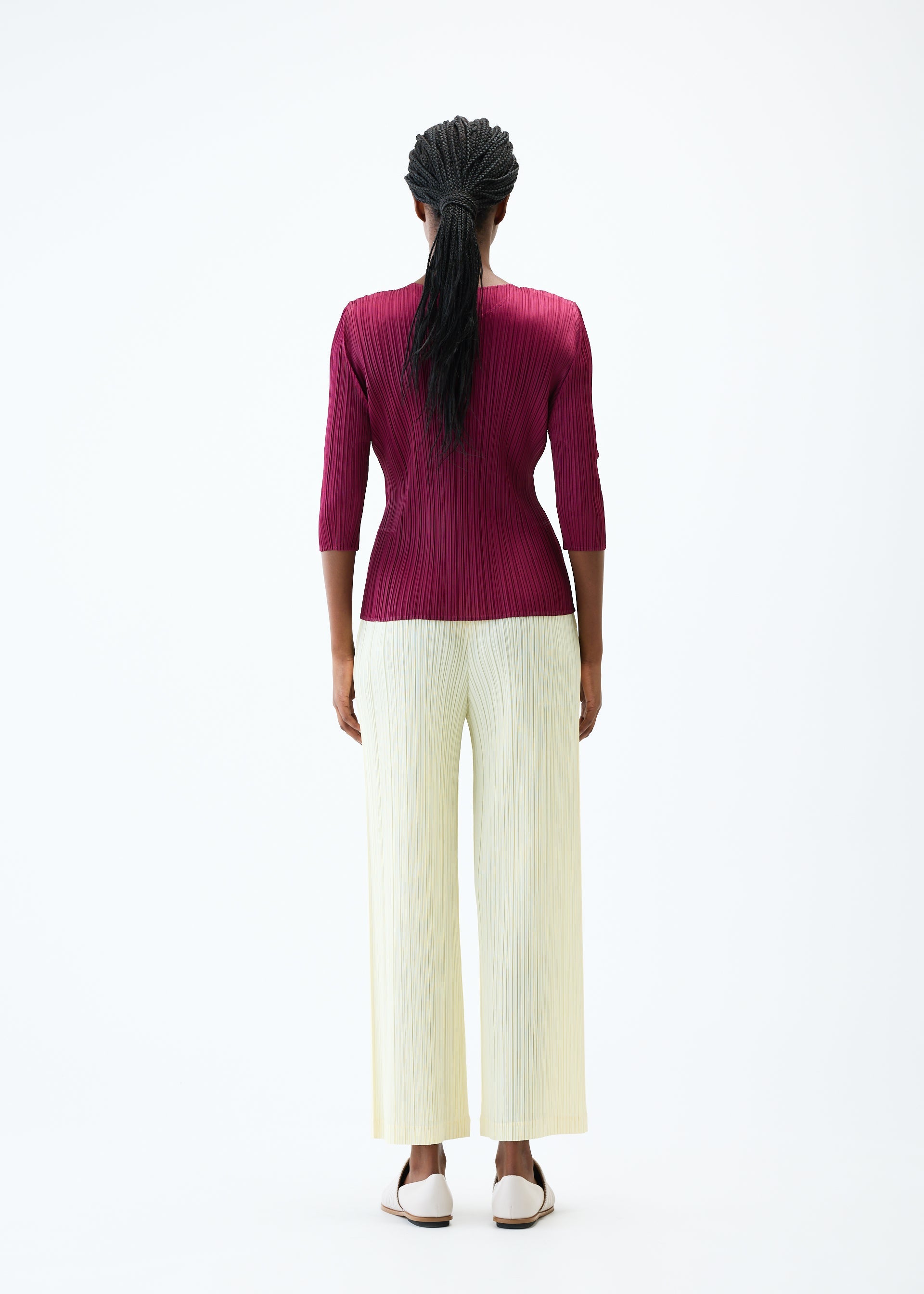 A model wears the PLEATS PLEASE ISSEY MIYAKE THICKER BOTTOMS 2 trousers.