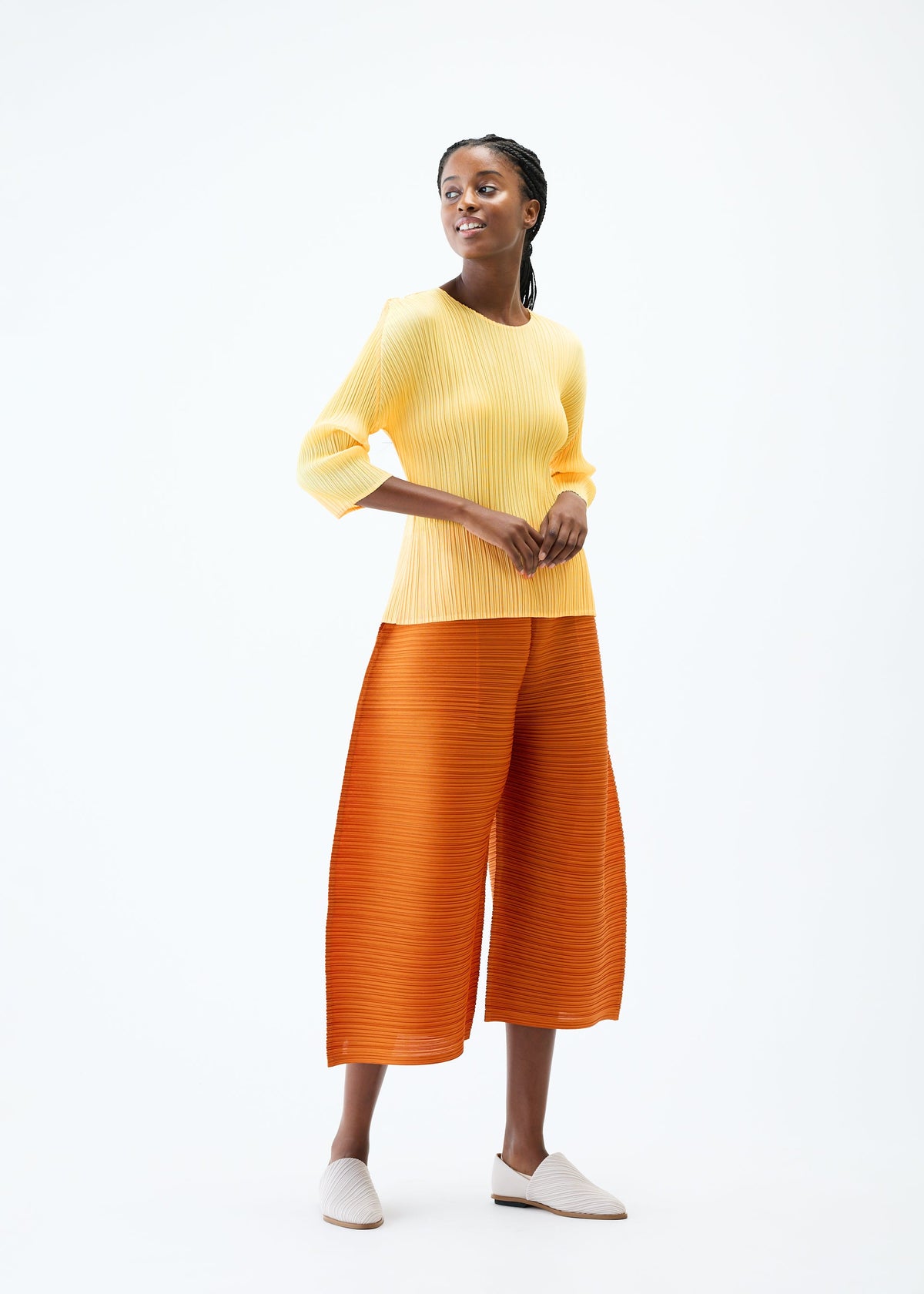 A model wears the PLEATS PLEASE ISSEY MIYAKE THICKER BOTTOMS 2 trousers.