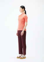 A model wears the PLEATS PLEASE ISSEY MIYAKE LOOP BOTTOMS trousers.
