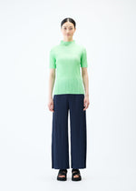 A model wears the PLEATS PLEASE ISSEY MIYAKE LOOP BOTTOMS trousers.