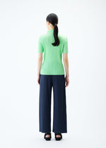 A model wears the PLEATS PLEASE ISSEY MIYAKE LOOP BOTTOMS trousers.