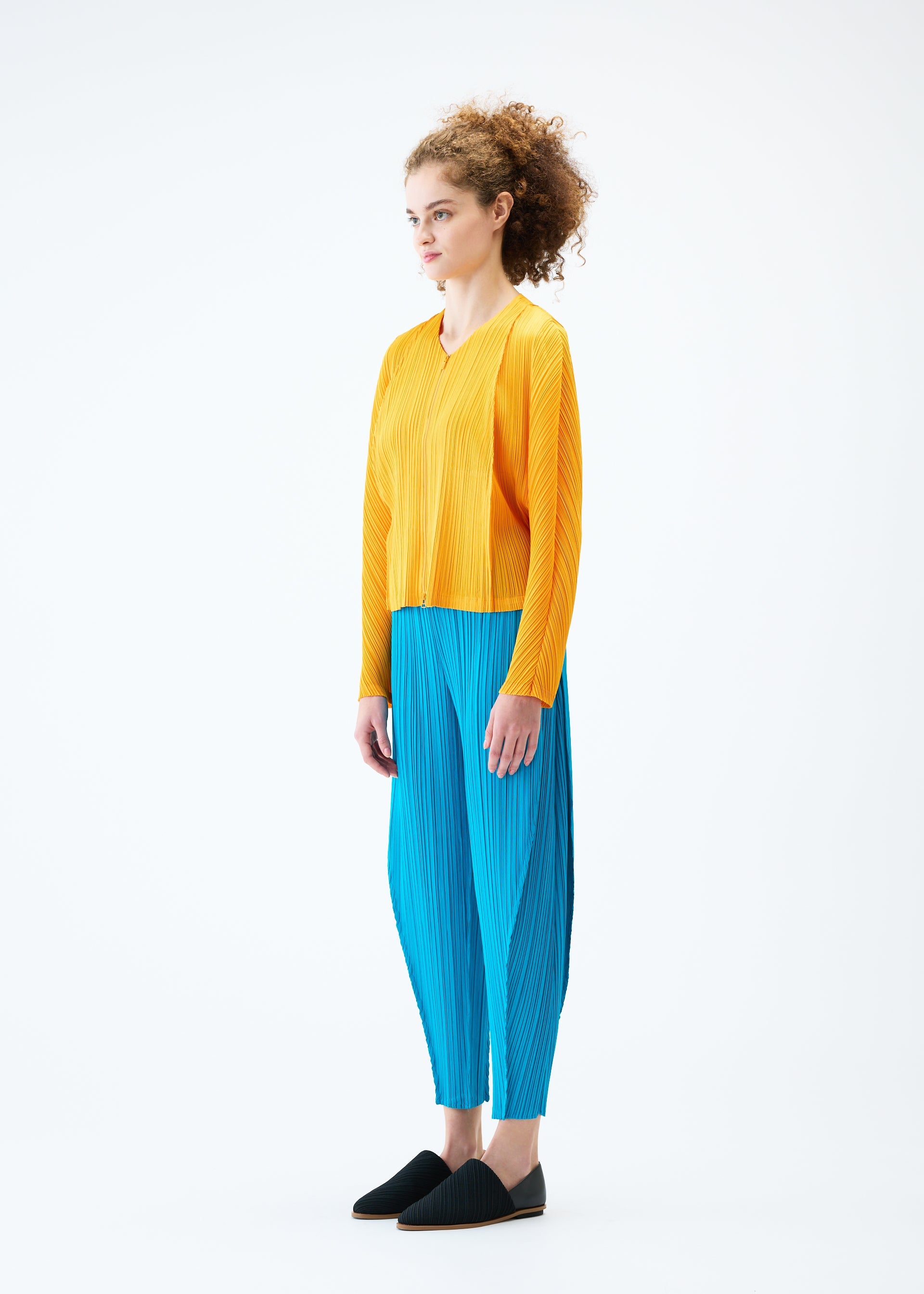 A model wears the PLEATS PLEASE ISSEY MIYAKE LANTERN trousers.