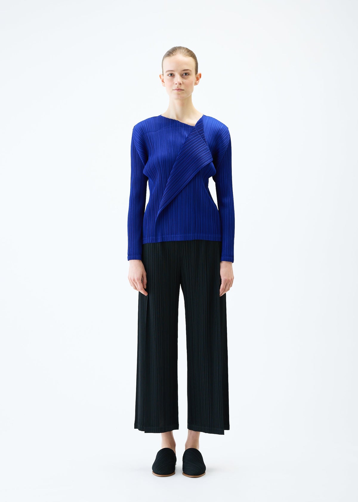 A model wears the PLEATS PLEASE ISSEY MIYAKE LIGHT WAVE trousers.