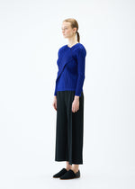 A model wears the PLEATS PLEASE ISSEY MIYAKE LIGHT WAVE trousers.