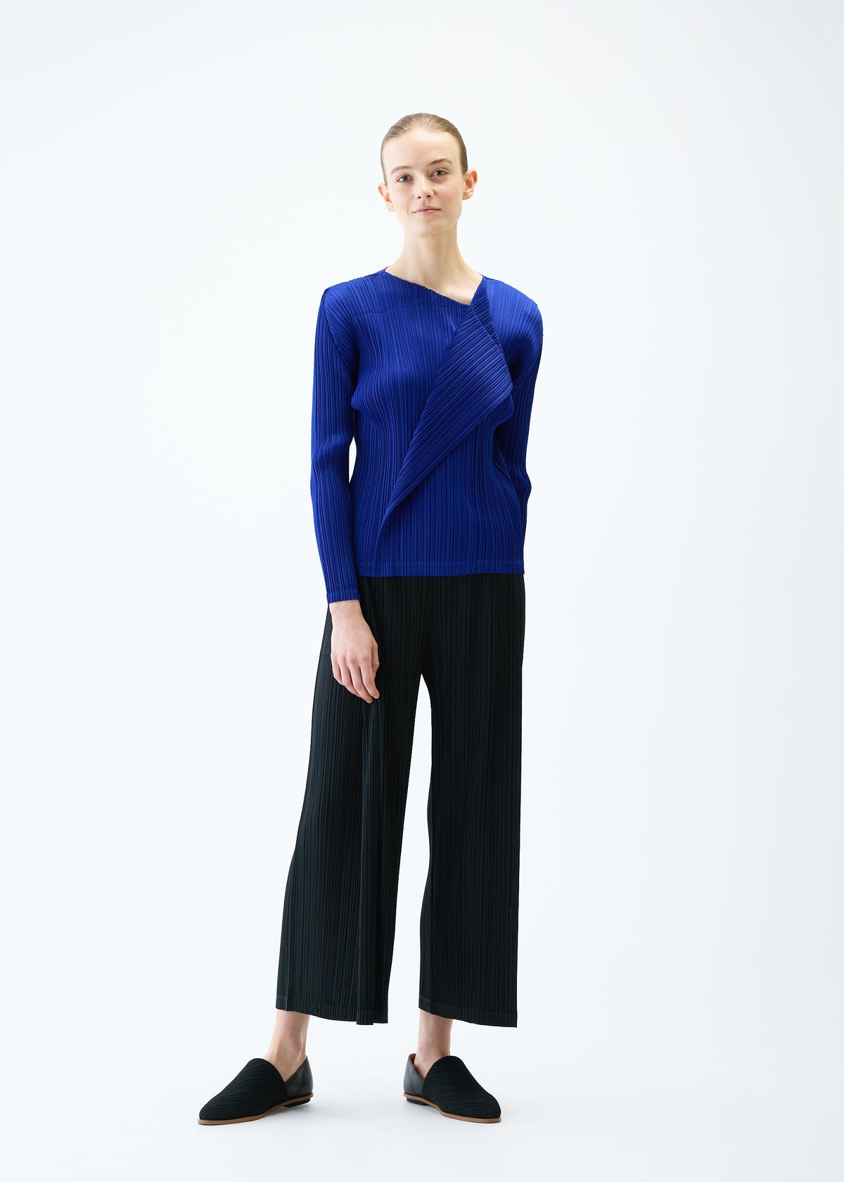 A model wears the PLEATS PLEASE ISSEY MIYAKE LIGHT WAVE trousers.