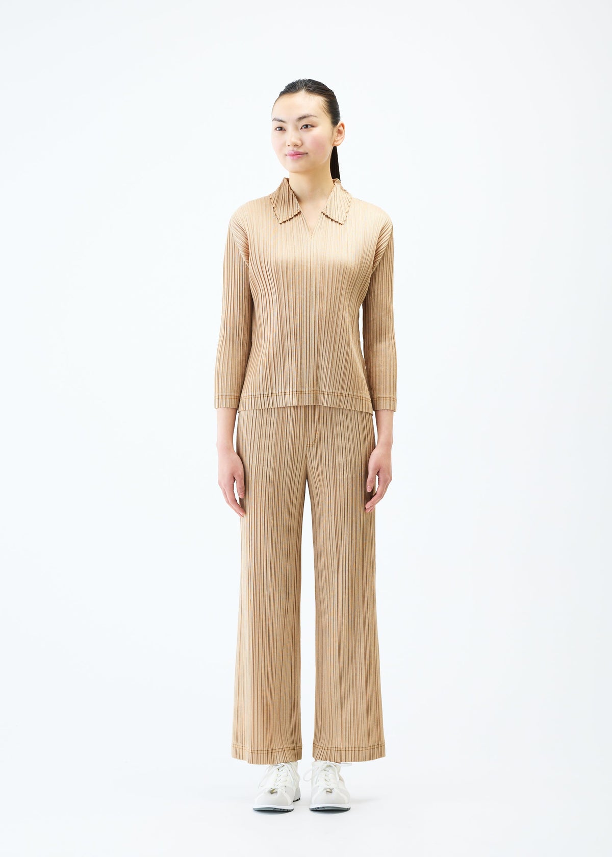 A model wears the PLEATS PLEASE ISSEY MIYAKE COTTON DENIM trousers.