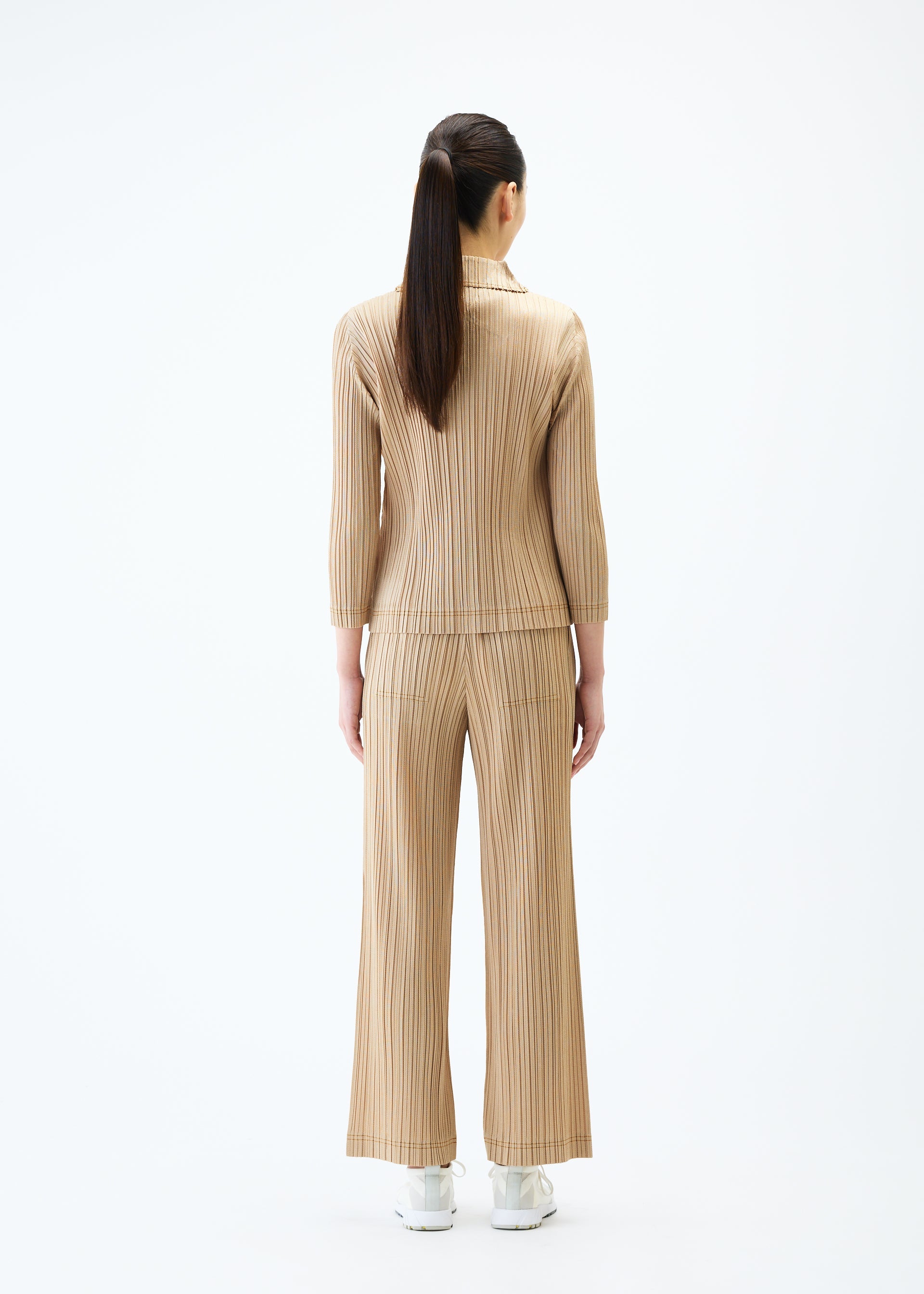 A model wears the PLEATS PLEASE ISSEY MIYAKE COTTON DENIM trousers.