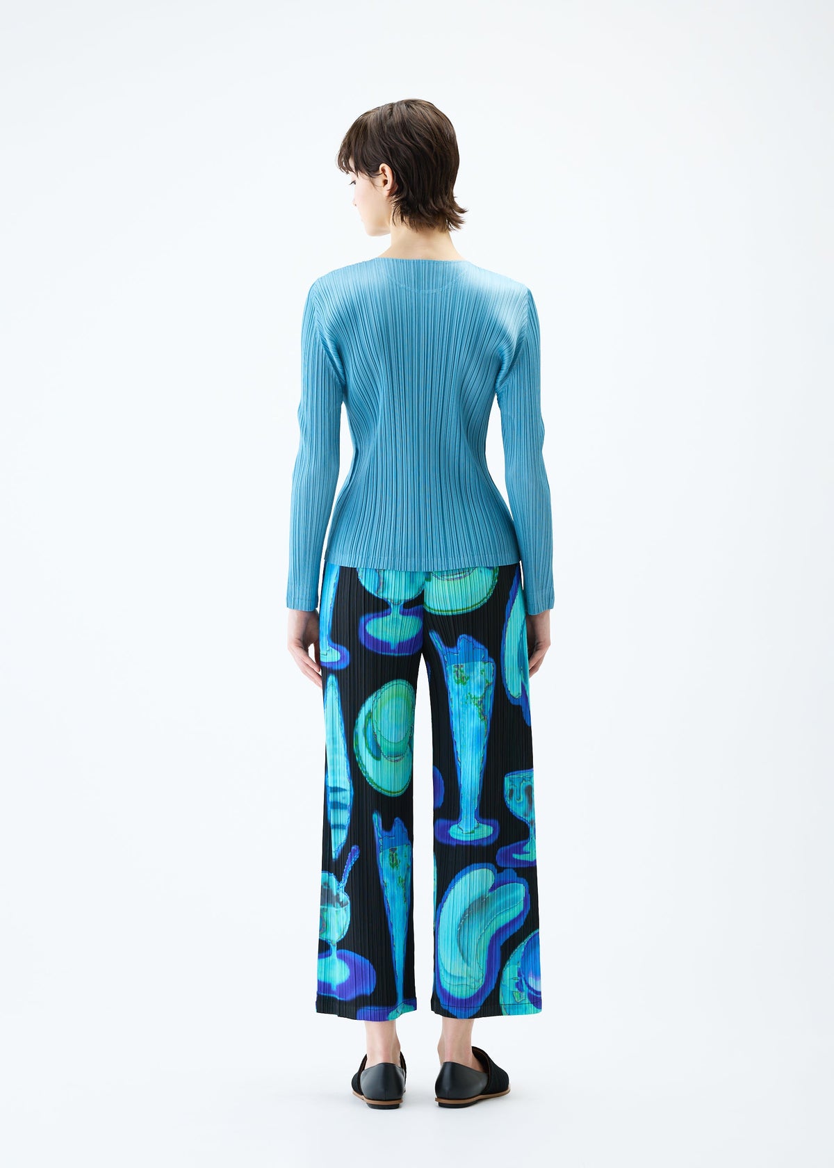 A model wears the PLEATS PLEASE ISSEY MIYAKE THERMAL FOODS trousers.