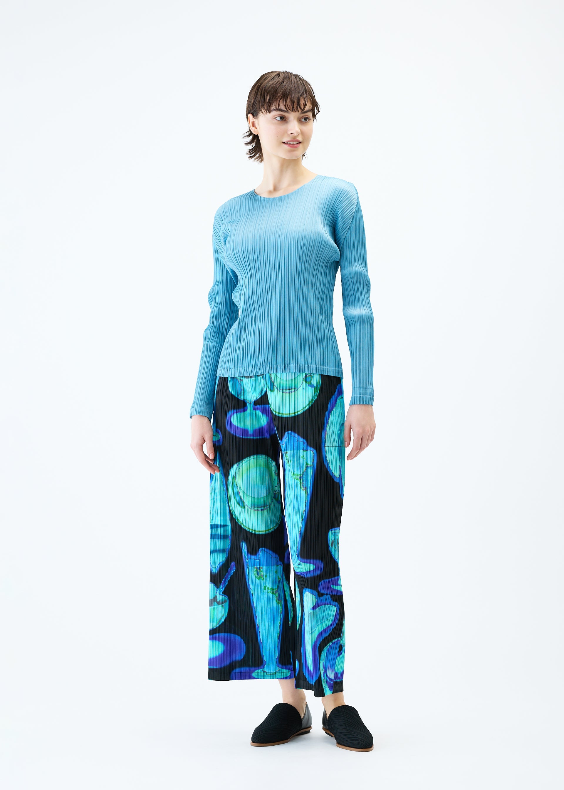 A model wears the PLEATS PLEASE ISSEY MIYAKE THERMAL FOODS trousers.