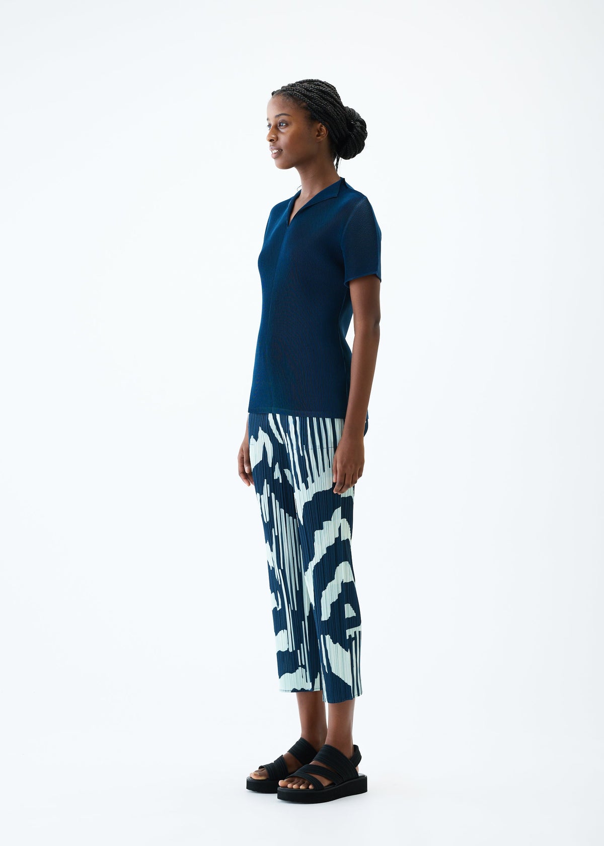A model wears the PLEATS PLEASE ISSEY MIYAKE REFRACTION trousers.