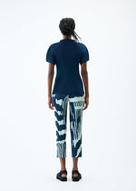 A model wears the PLEATS PLEASE ISSEY MIYAKE REFRACTION trousers.