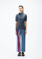 A model wears the PLEATS PLEASE ISSEY MIYAKE GRAINY COLORS trousers.