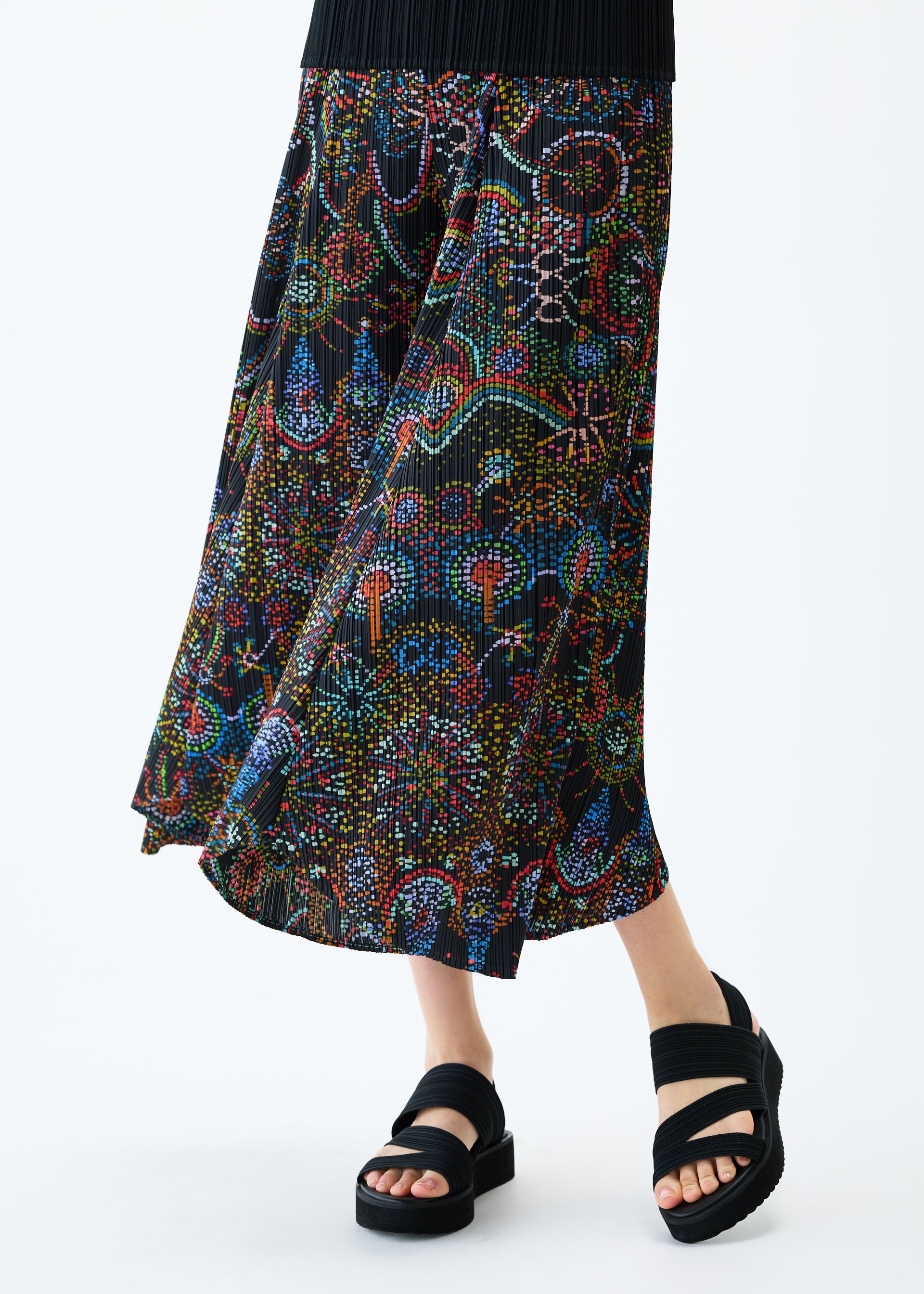 A model wears the PLEATS PLEASE ISSEY MIYAKE LIGHT FESTIVAL trousers.