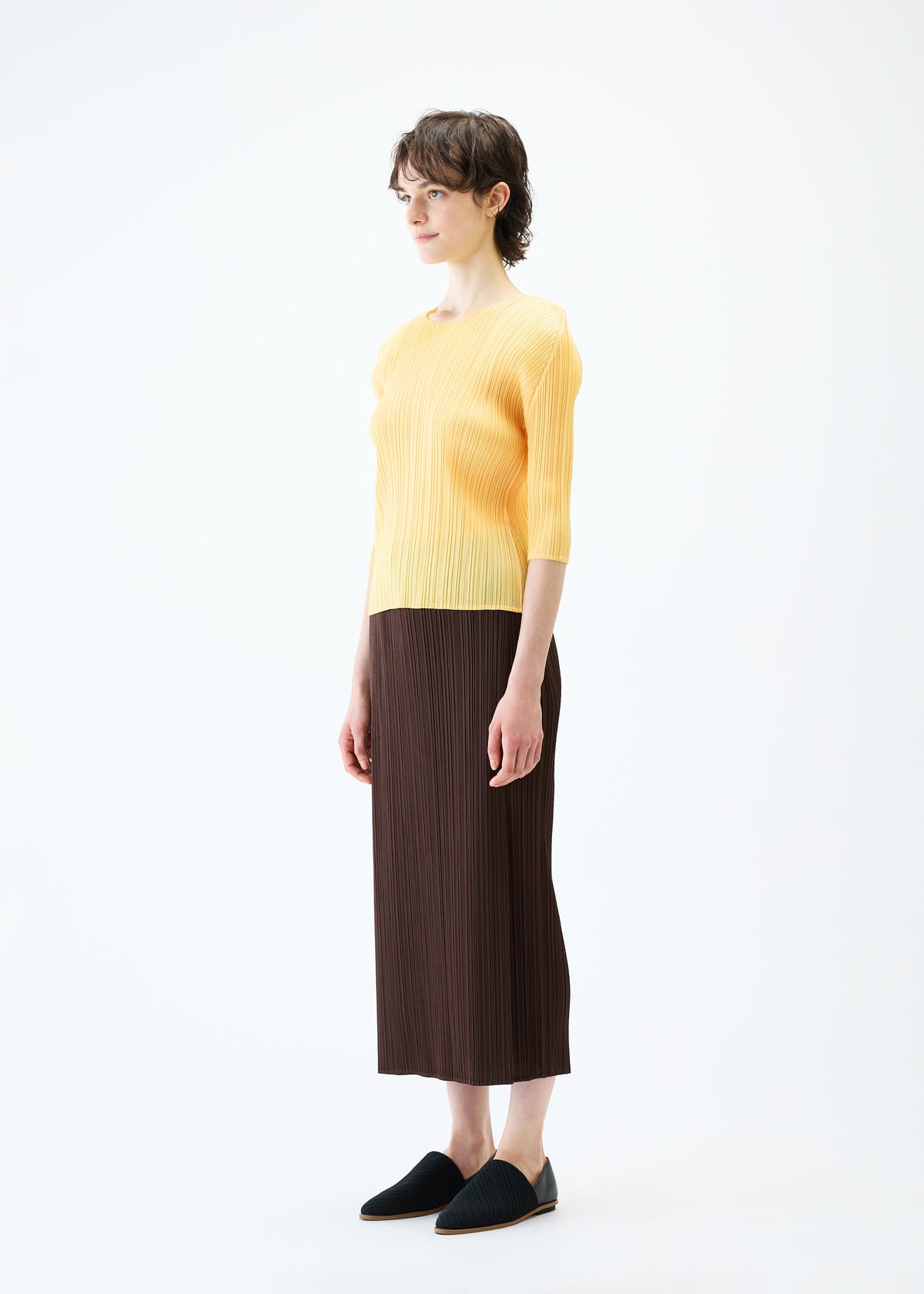 A model wears the PLEATS PLEASE ISSEY MIYAKE MONTHLY COLORS MARCH skirt.