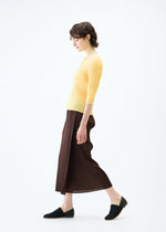 A model wears the PLEATS PLEASE ISSEY MIYAKE MONTHLY COLORS MARCH skirt.