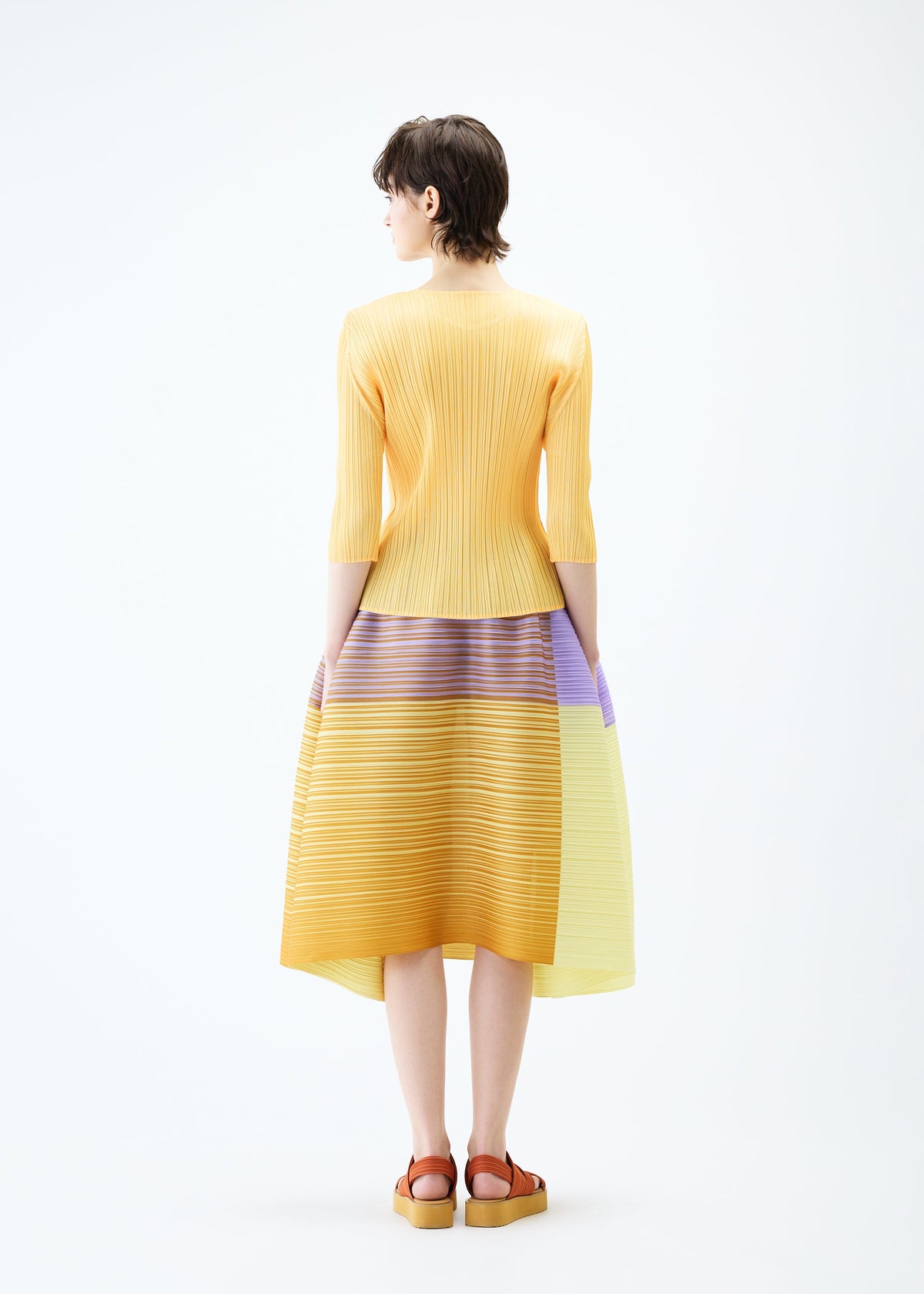 A model wears the PLEATS PLEASE ISSEY MIYAKE PHOTON BOUNCE skirt.