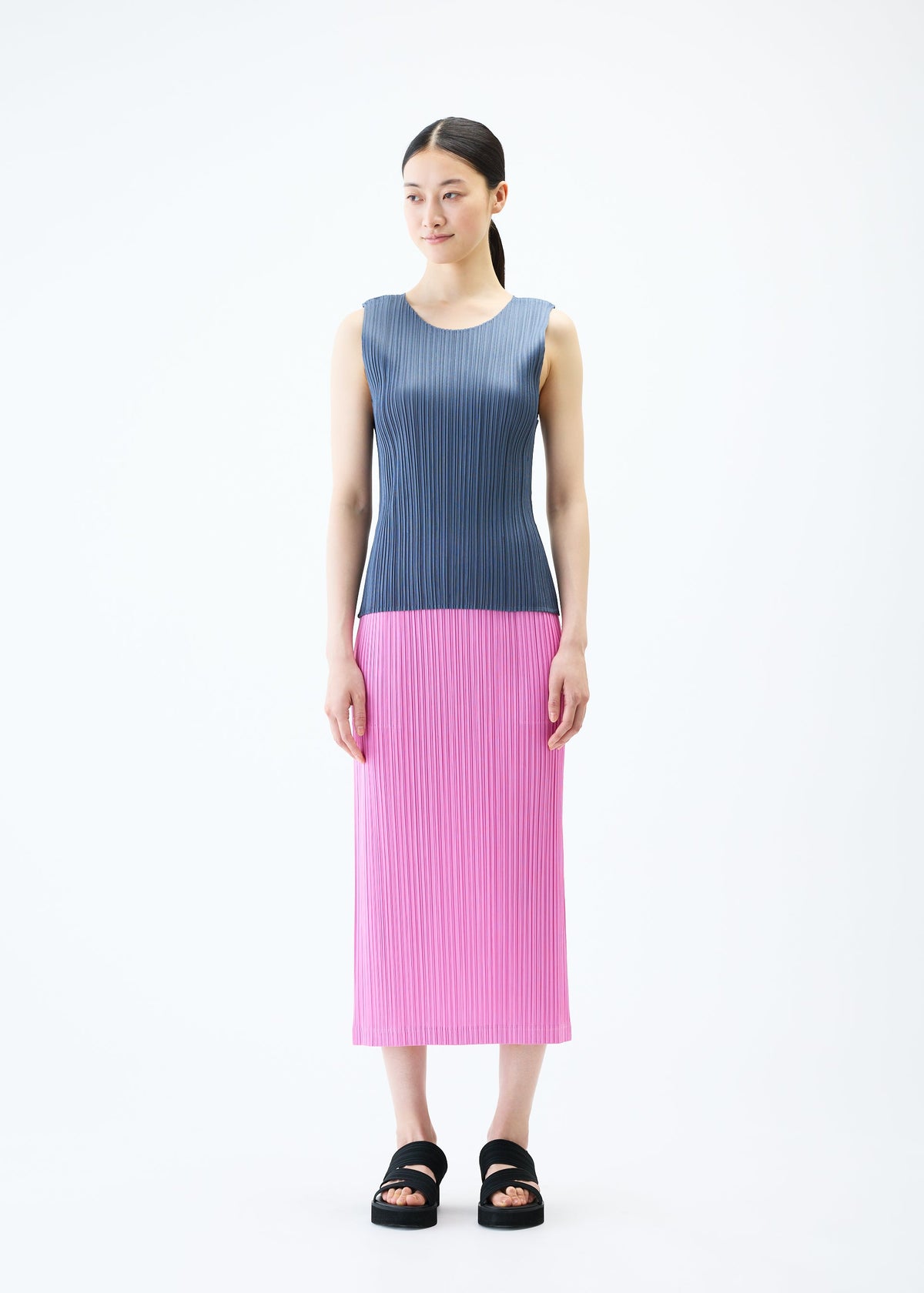 A model wears the PLEATS PLEASE ISSEY MIYAKE LOOP BOTTOMS skirt.