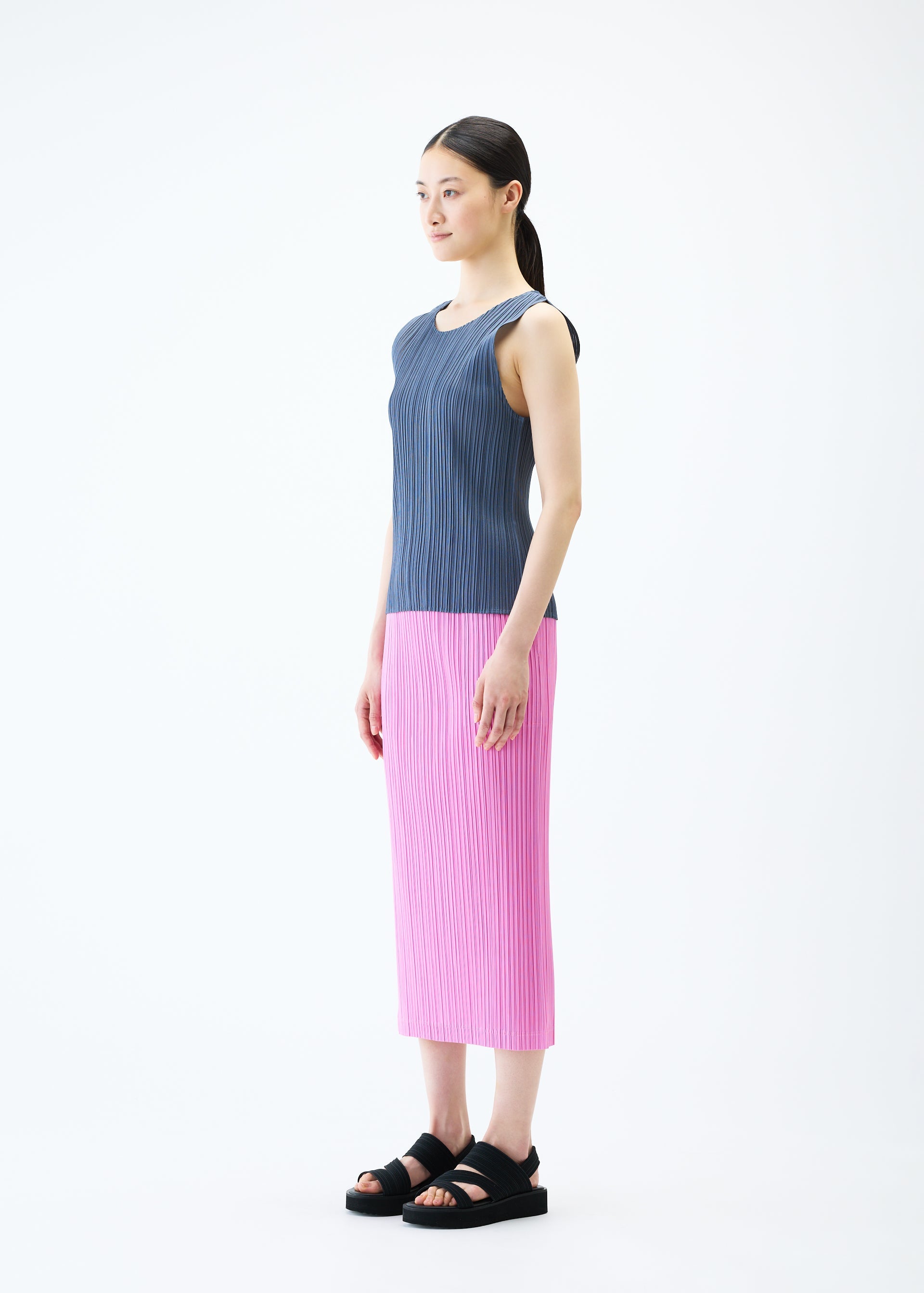A model wears the PLEATS PLEASE ISSEY MIYAKE LOOP BOTTOMS skirt.