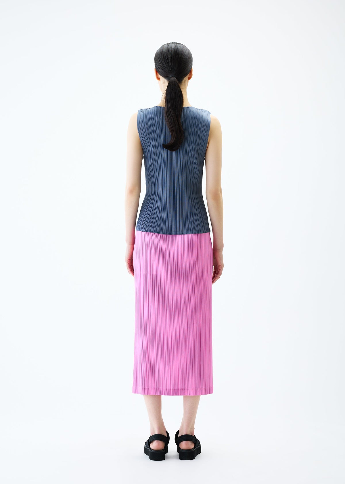 A model wears the PLEATS PLEASE ISSEY MIYAKE LOOP BOTTOMS skirt.