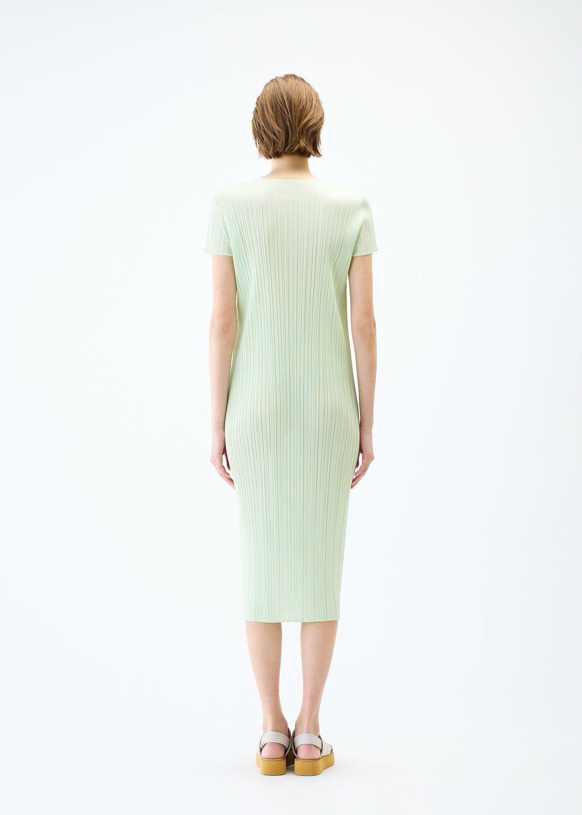 A model wears the PLEATS PLEASE ISSEY MIYAKE MONTHLY COLORS : JUNE dress.