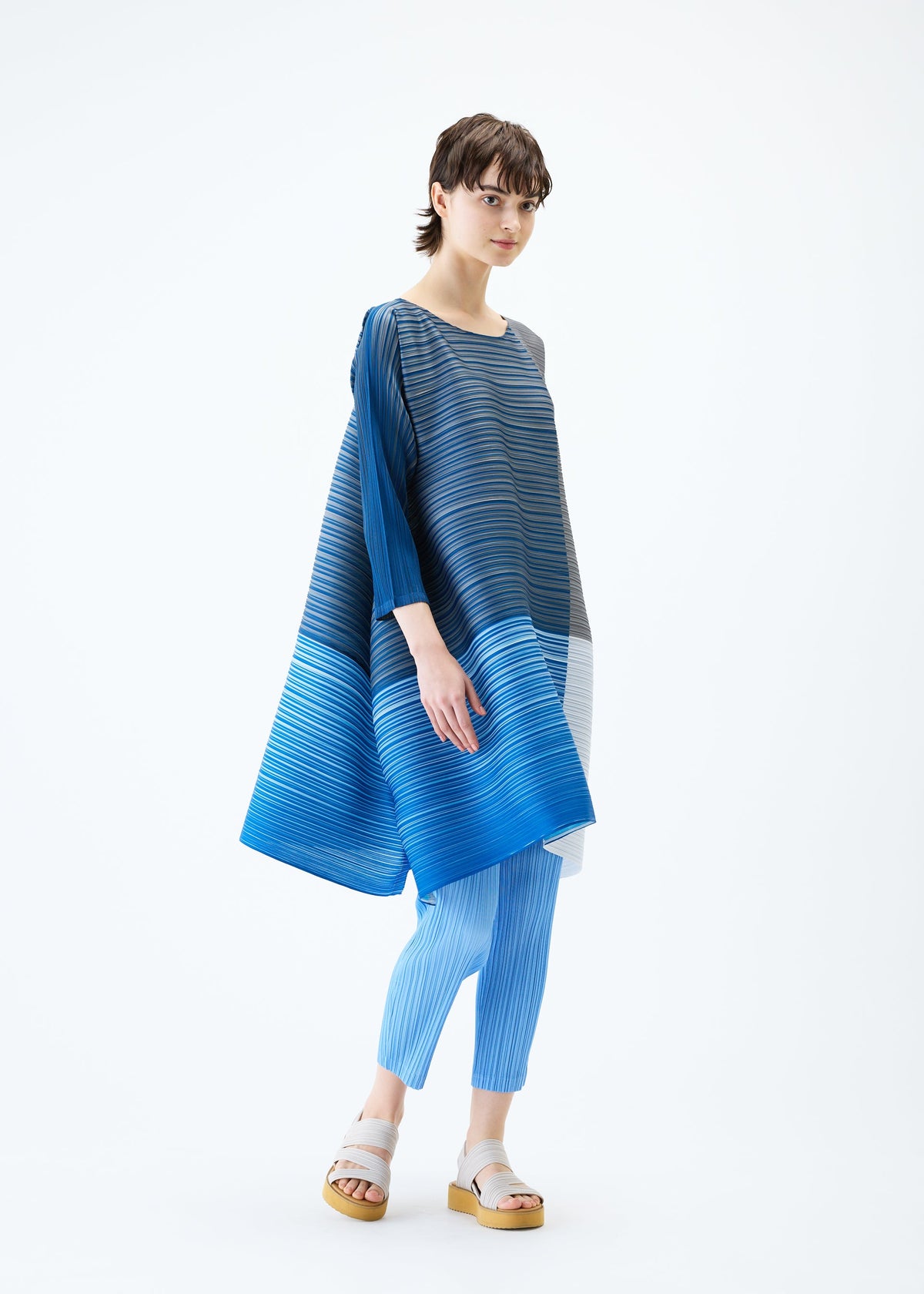 A model wears the PLEATS PLEASE ISSEY MIYAKE PHOTON BOUNCE dress.