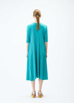 A model wears the PLEATS PLEASE ISSEY MIYAKE MELLOW PLEATS dress.
