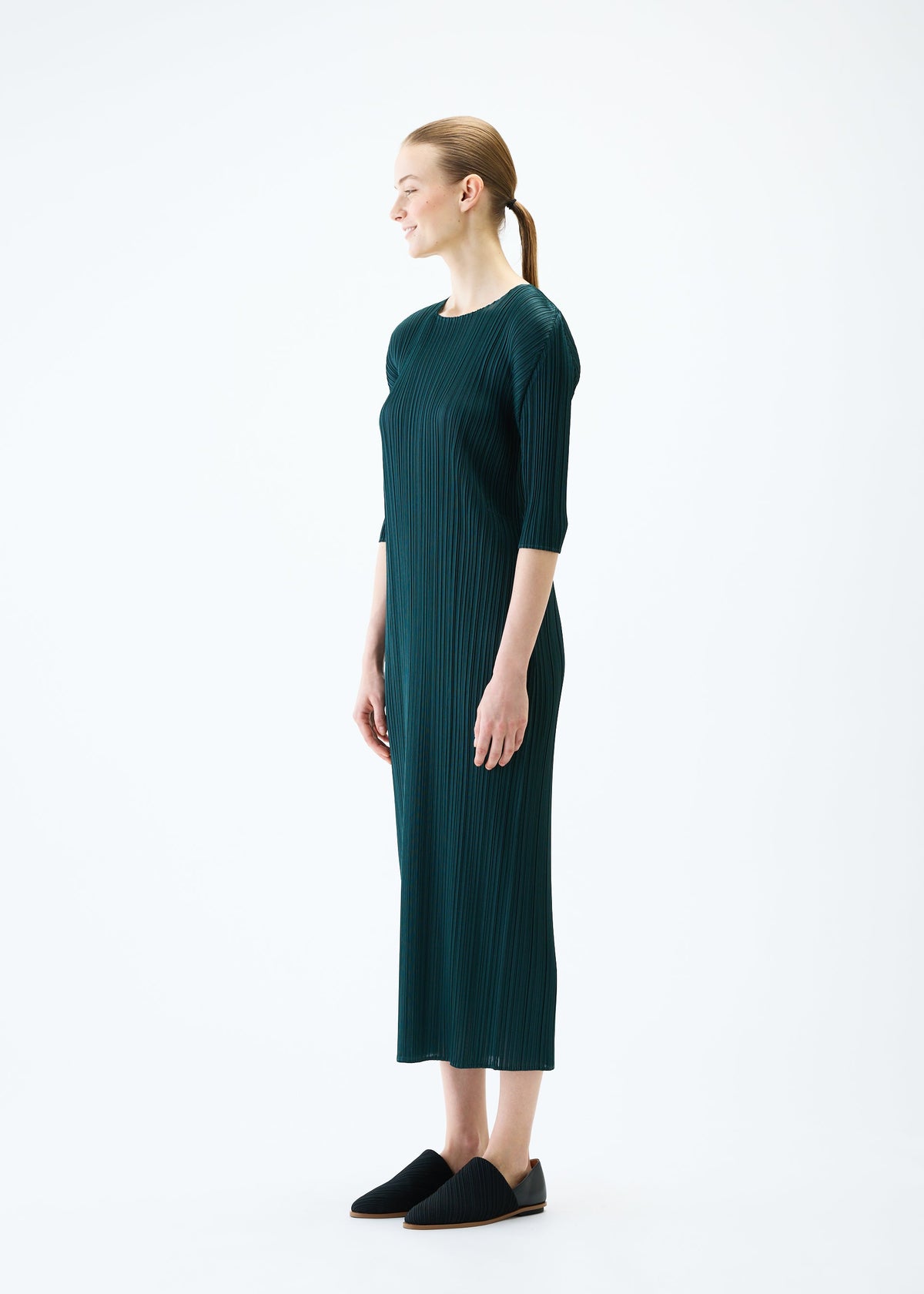 A model wears the PLEATS PLEASE ISSEY MIYAKE MERRY BICOLOR dress.