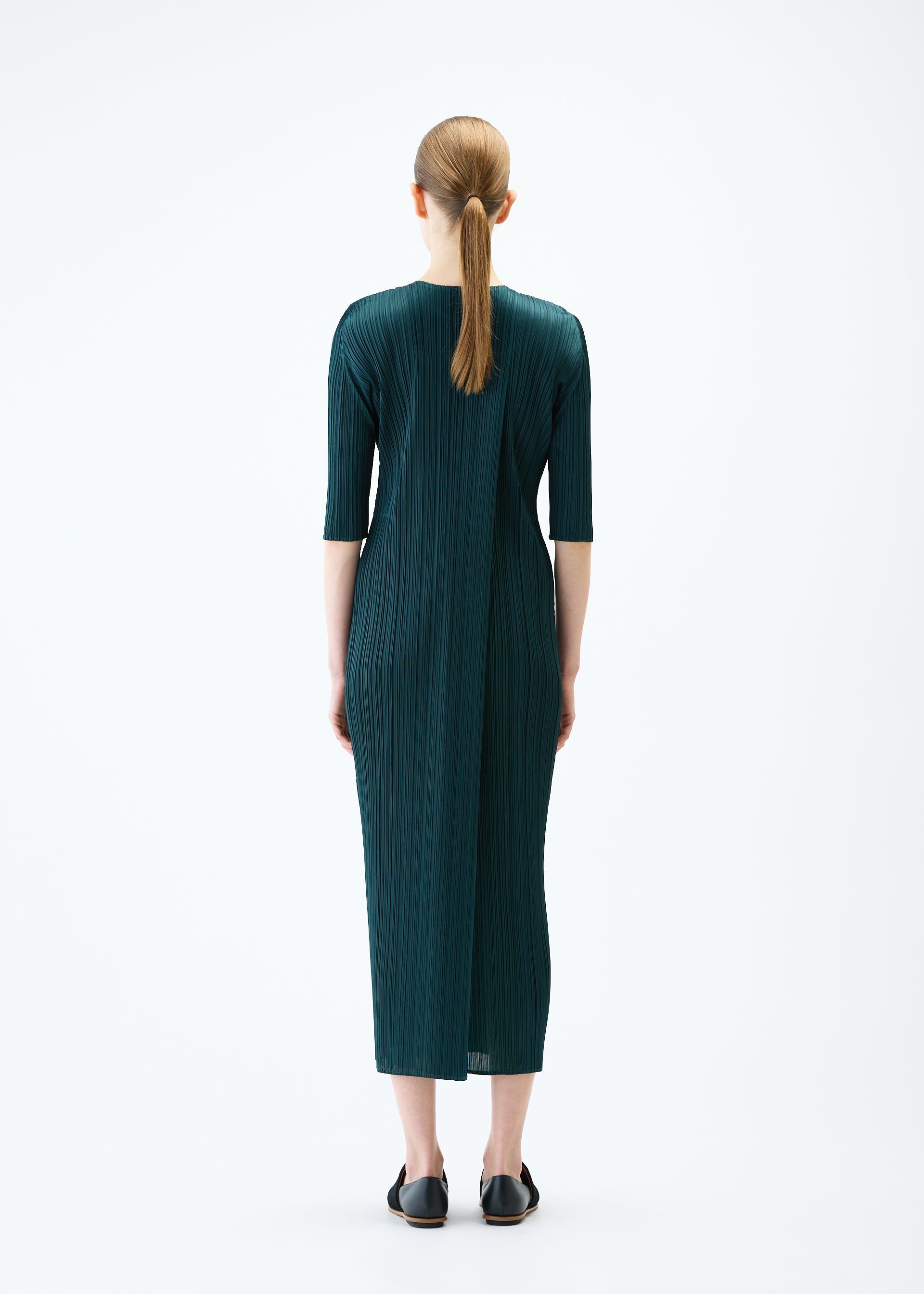 A model wears the PLEATS PLEASE ISSEY MIYAKE MERRY BICOLOR dress.