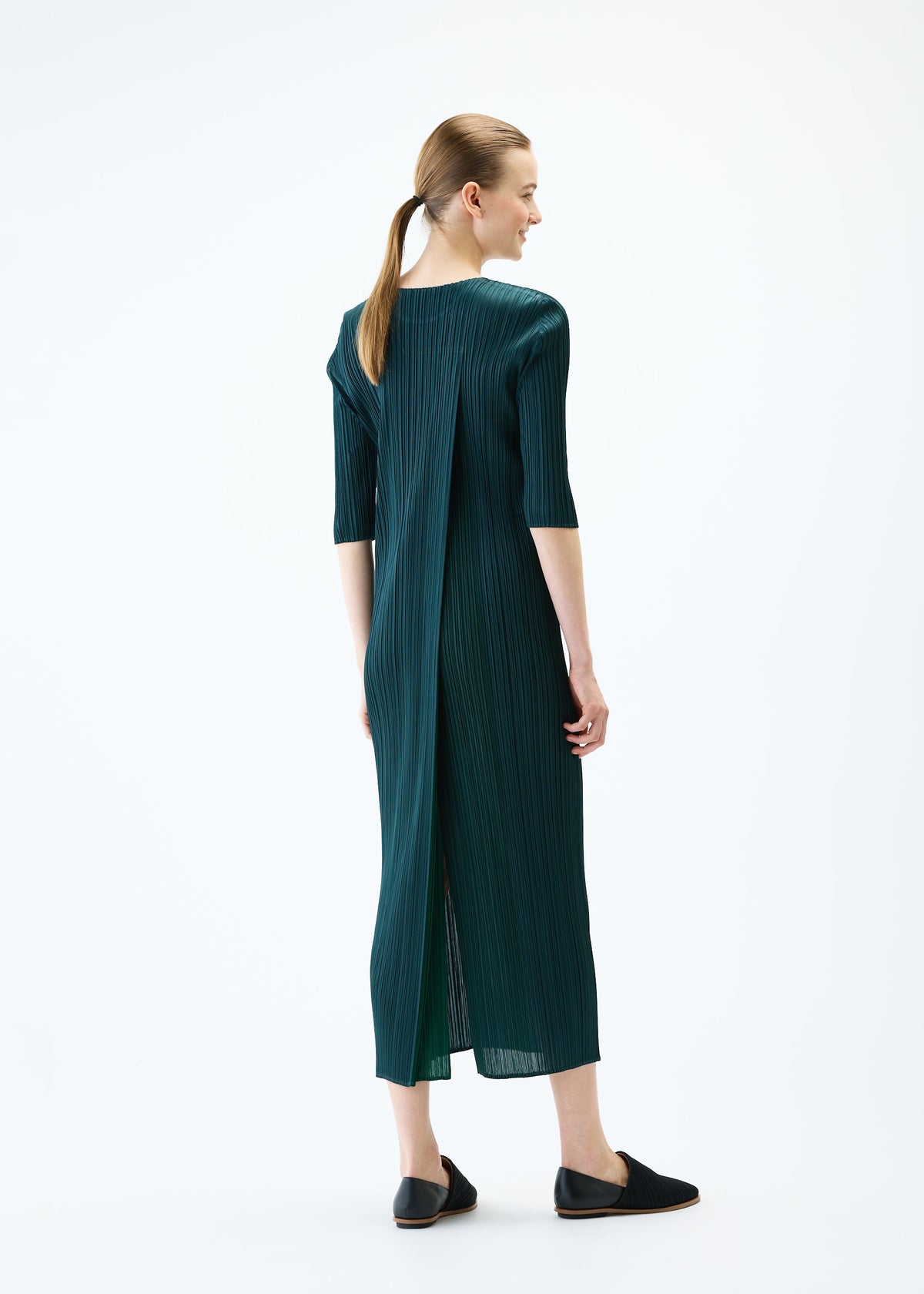 A model wears the PLEATS PLEASE ISSEY MIYAKE MERRY BICOLOR dress.