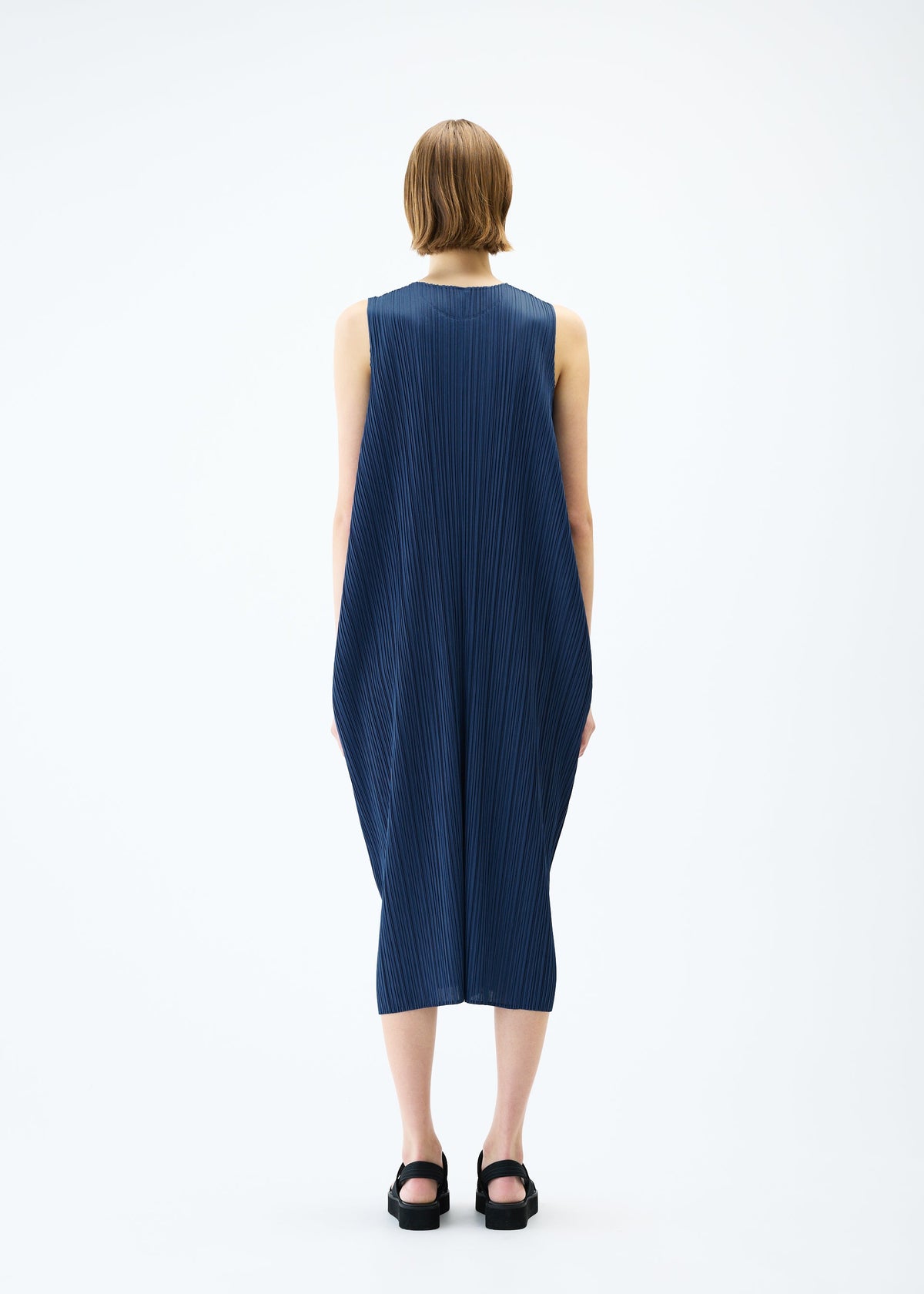 A model wears the PLEATS PLEASE ISSEY MIYAKE LAMP SHADE dress.