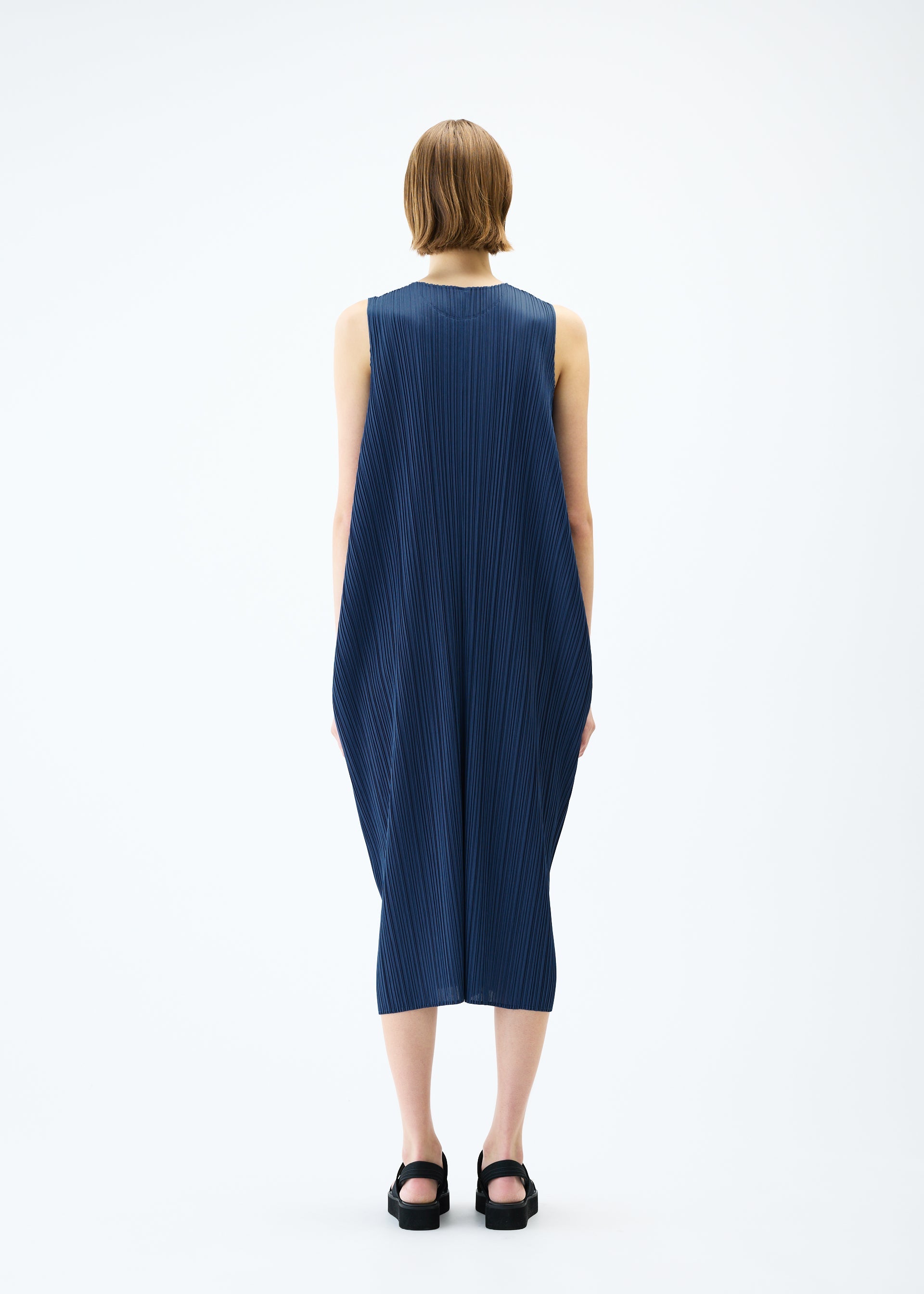 A model wears the PLEATS PLEASE ISSEY MIYAKE LAMP SHADE dress.