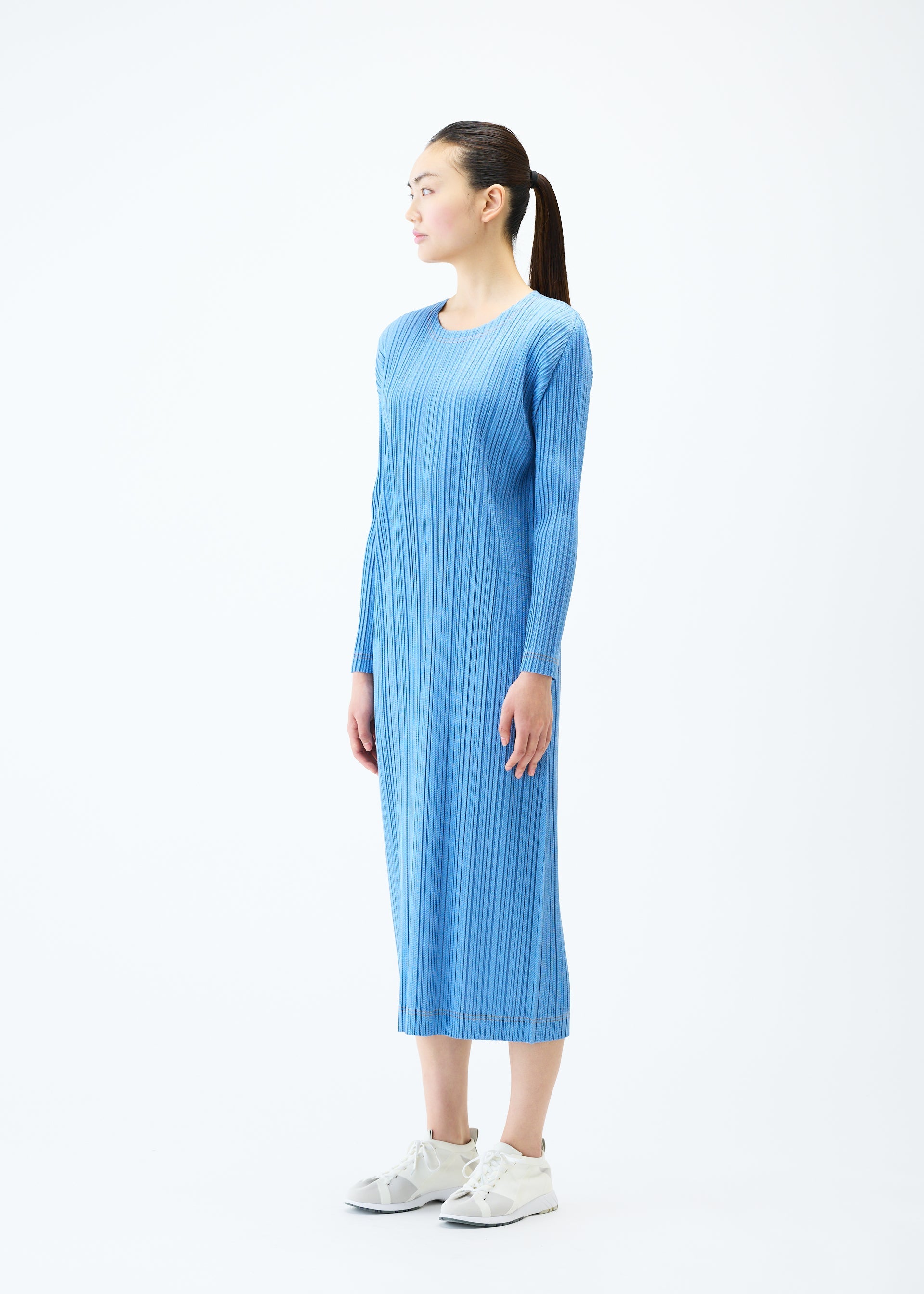 A model wears the PLEATS PLEASE ISSEY MIYAKE COTTON DENIM dress.