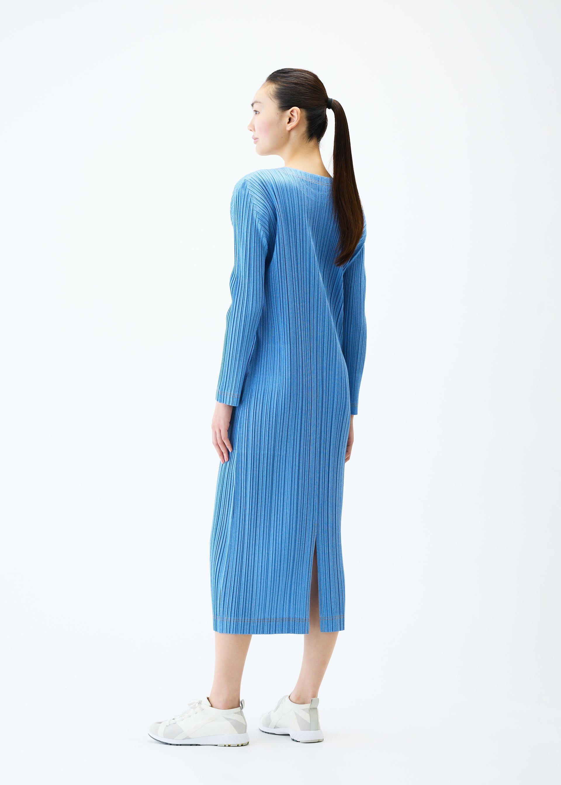 A model wears the PLEATS PLEASE ISSEY MIYAKE COTTON DENIM dress.