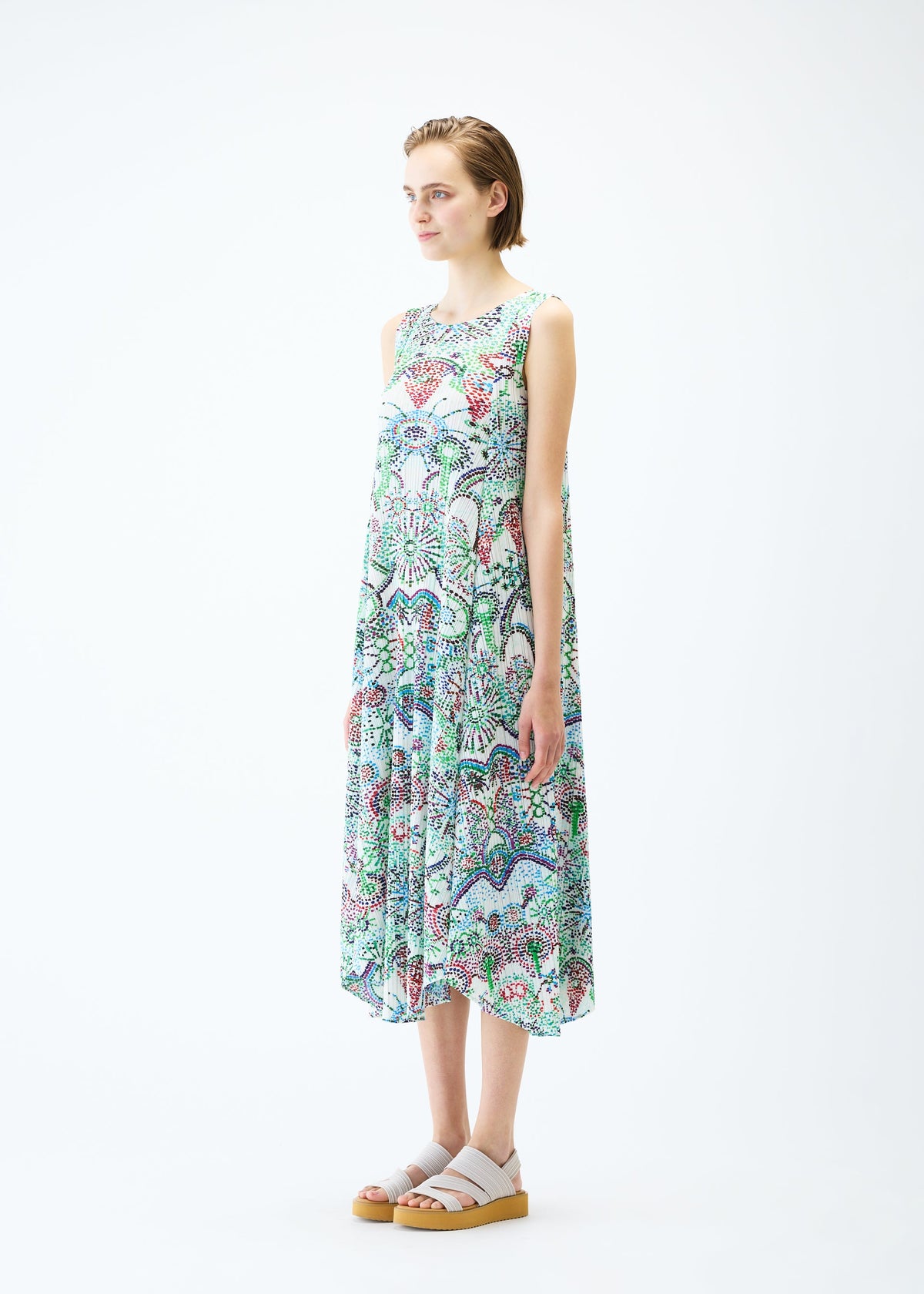 A model wears the PLEATS PLEASE ISSEY MIYAKE LIGHT FESTIVAL dress.