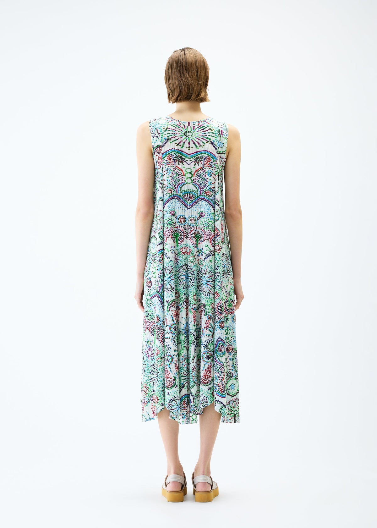 A model wears the PLEATS PLEASE ISSEY MIYAKE LIGHT FESTIVAL dress.