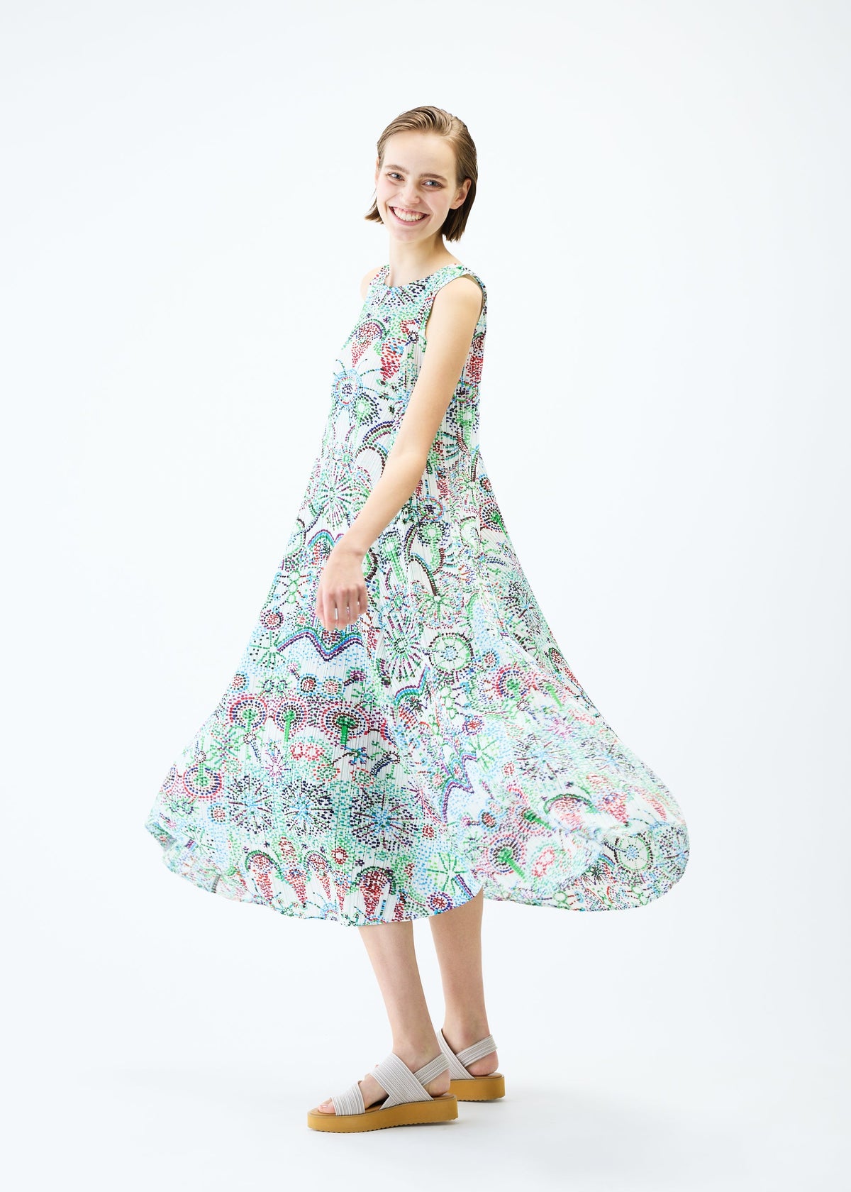 A model wears the PLEATS PLEASE ISSEY MIYAKE LIGHT FESTIVAL dress.