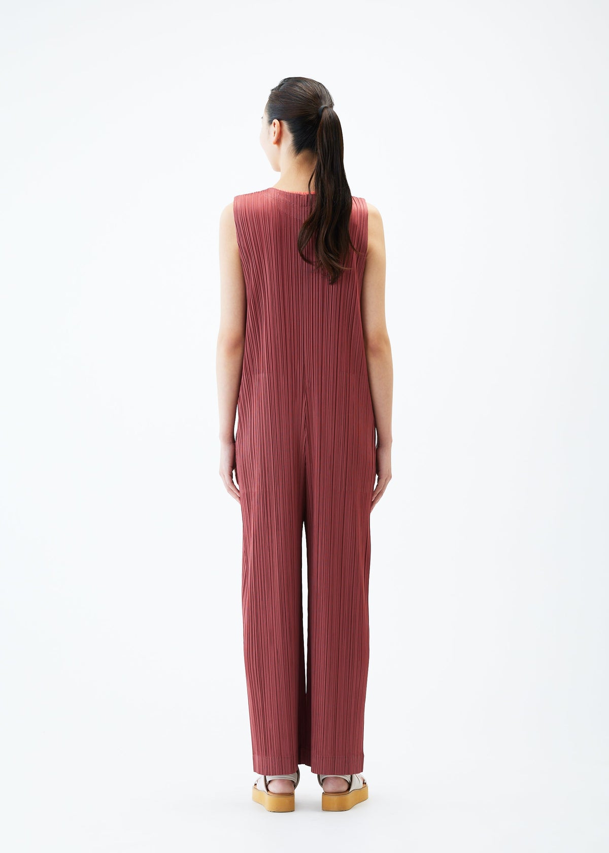 A model wears the PLEATS PLEASE ISSEY MIYAKE MONTHLY COLORS MAY jumpsuit.