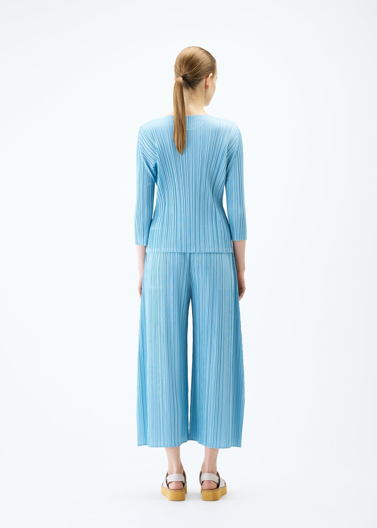 A model wears the PLEATS PLEASE ISSEY MIYAKE MELLOW PLEATS top.