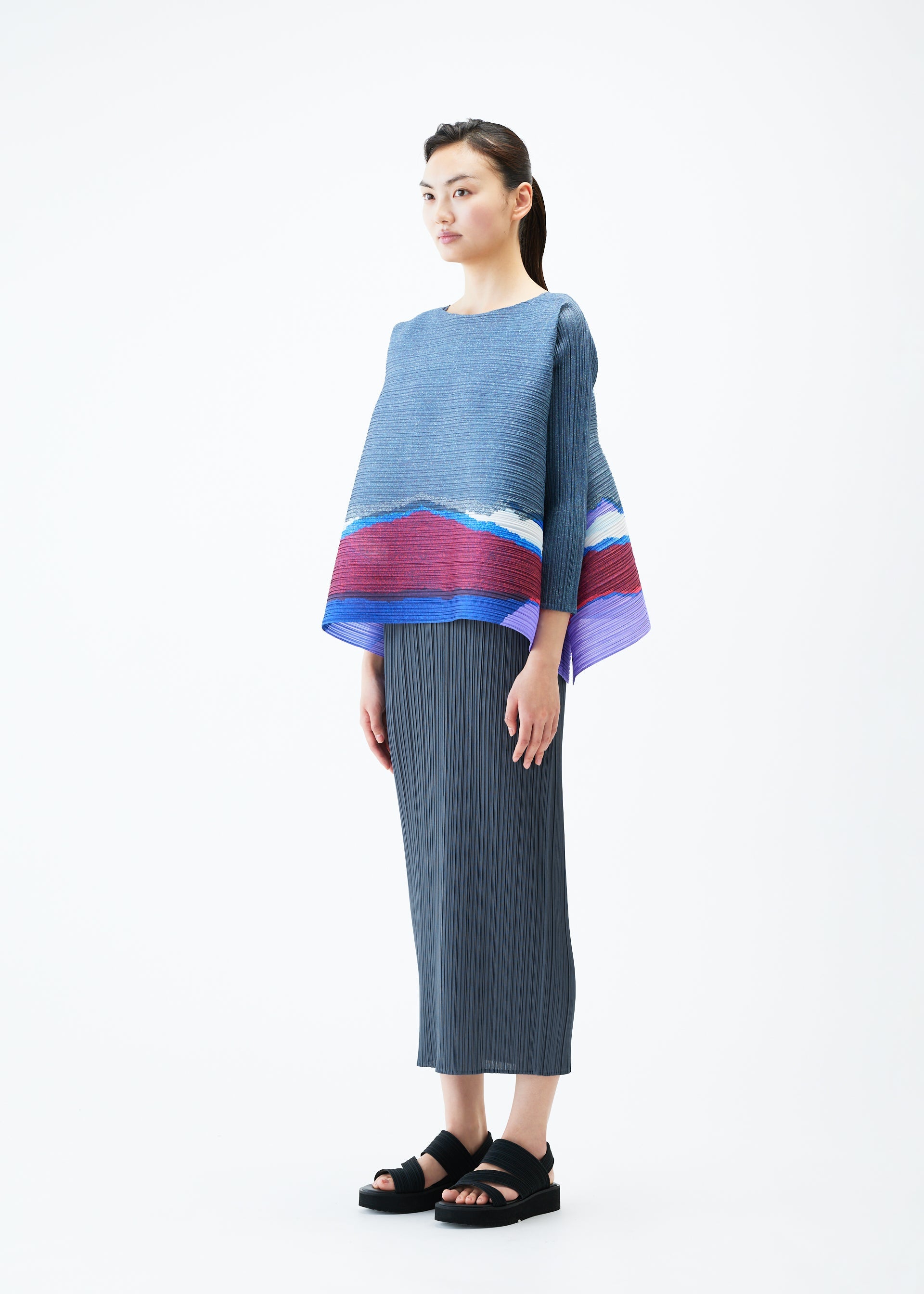 A model wears the PLEATS PLEASE ISSEY MIYAKE GRAINY COLORS top.